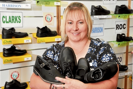 Back to school shoe shop lady, holding Harrison t-bars, Clarks and Roc shoes